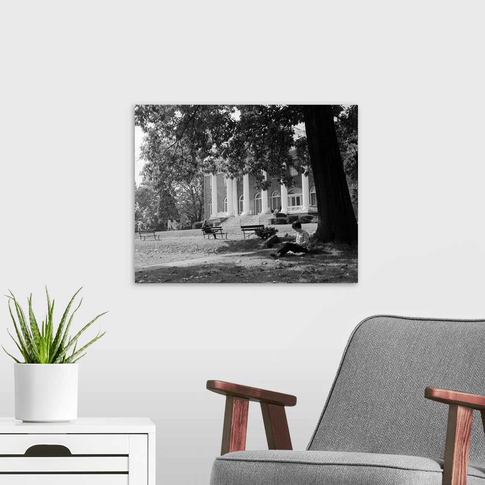 A modern room featuring 1960's Anonymous Silhouetted Female College Student Sitting Under Tree Studying With Campus Build...