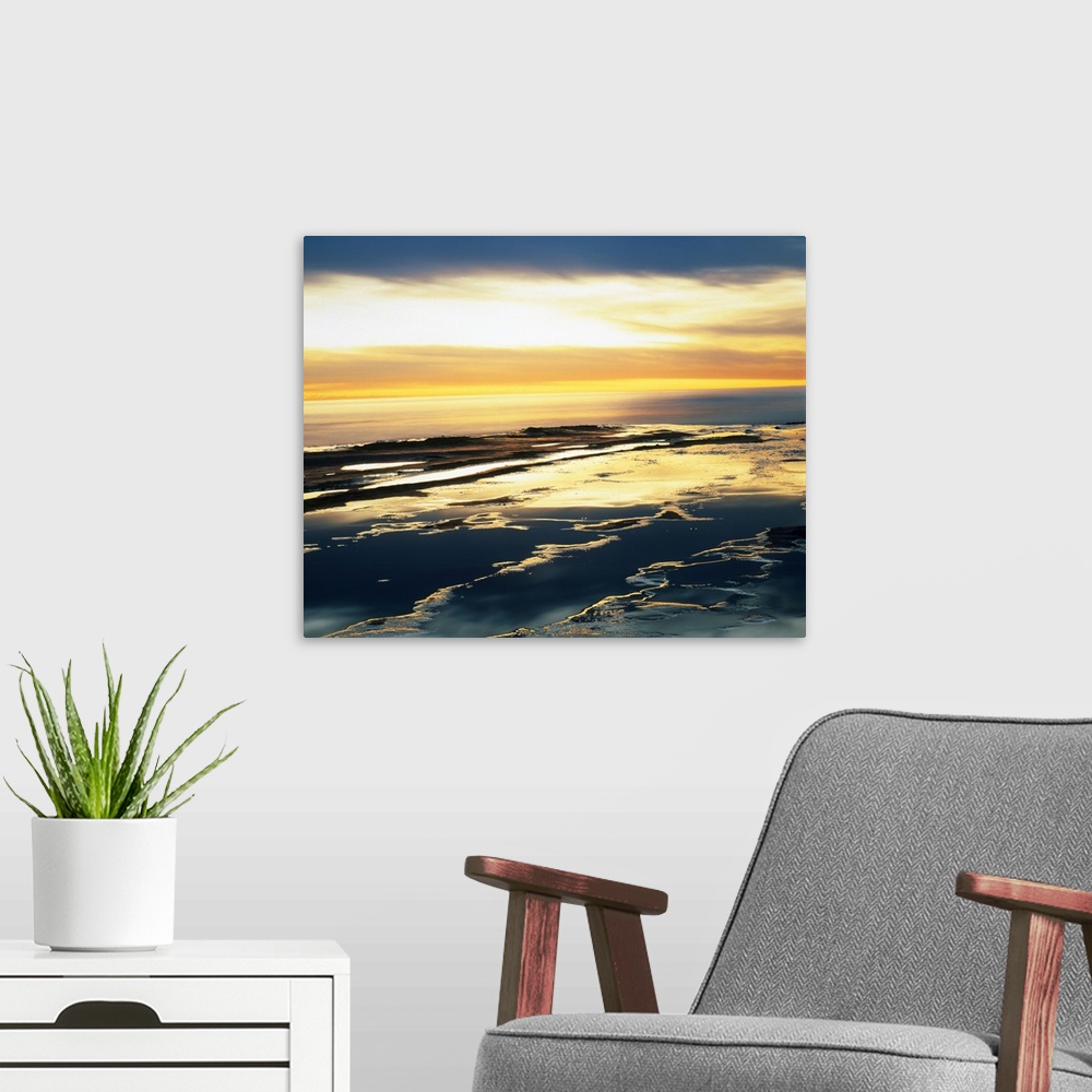 A modern room featuring Giant photograph taken from an aerial view shows the Pacific Ocean as it begins to make its way t...