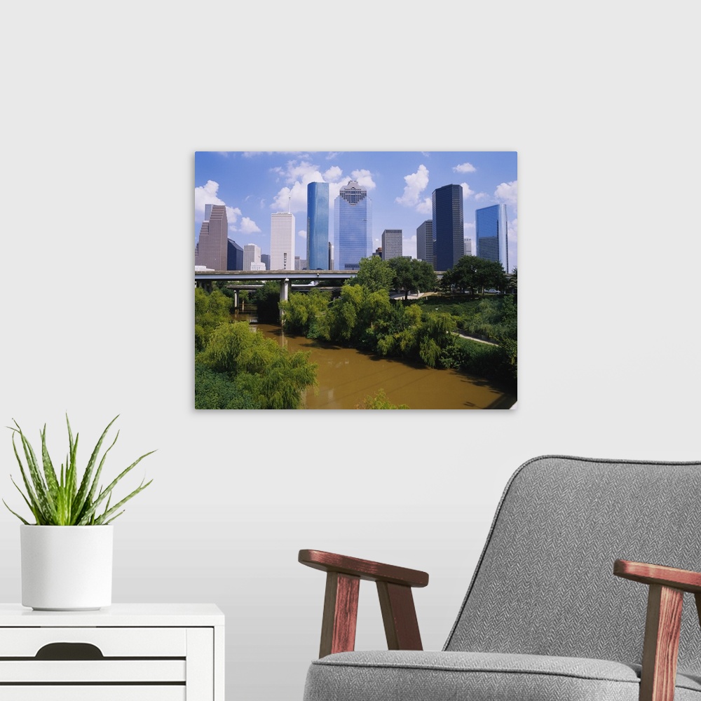 A modern room featuring This is a nearly square landscape photograph of cityos downtown skyscrapers and a river that pass...
