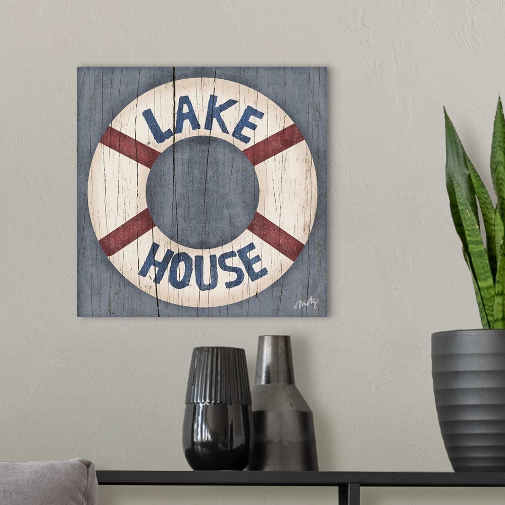A modern room featuring This decorative artwork of a ring buoy features the words, Lake House, over it with a cracked woo...