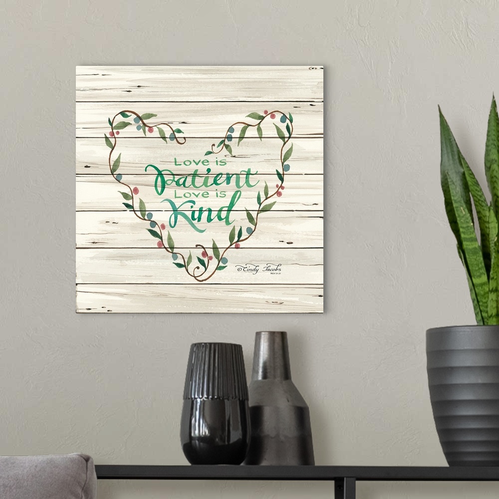 A modern room featuring Decorative artwork featuring these words over white shiplap: Love is Patient. Love is kind.