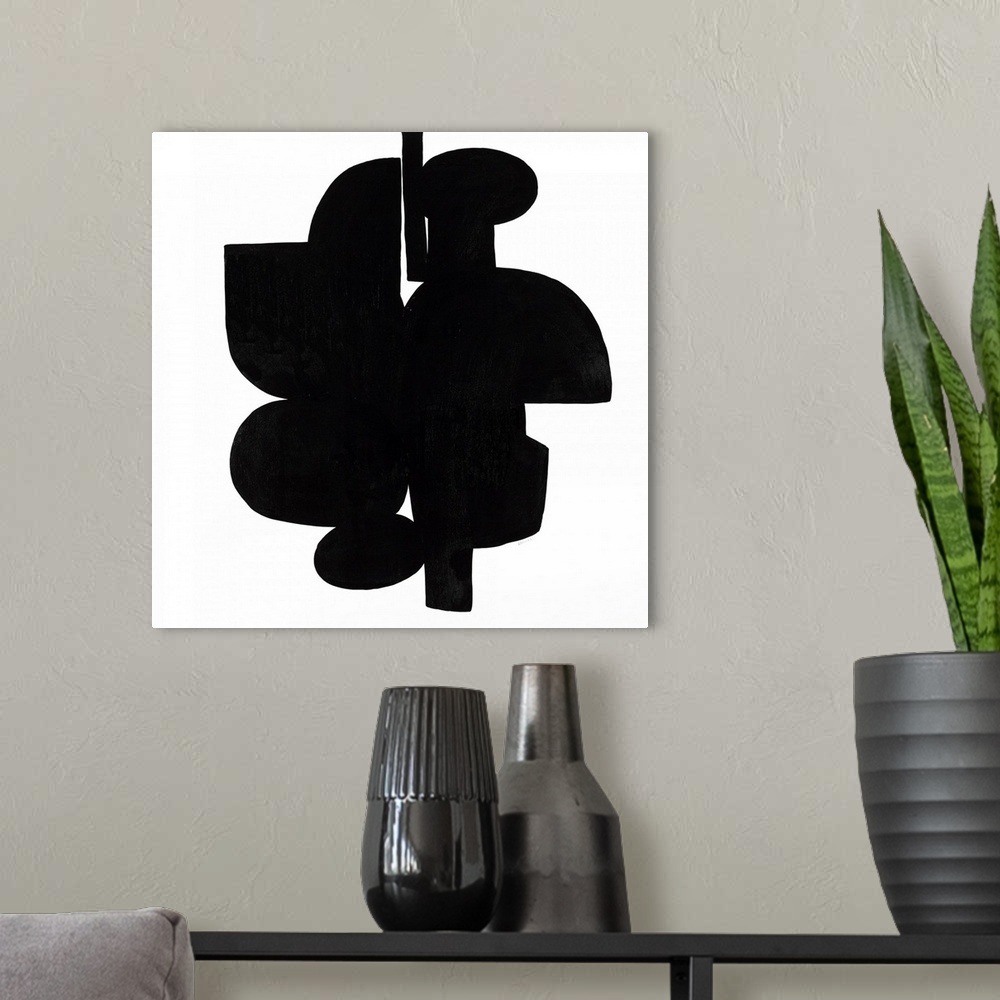 A modern room featuring Square art that has dark black shapes connecting on a white background with a minimalist feel.