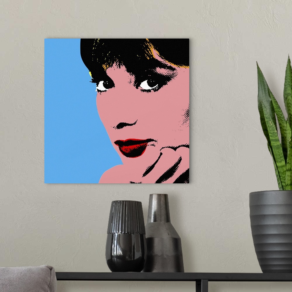 A modern room featuring Retro artwork of Audrey Hepburn where only her face and hand holding it up are shown.