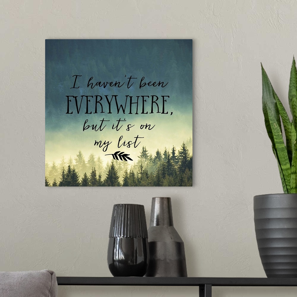 A modern room featuring Handwritten message about adventure and travel, over an image of a misty pine forest.