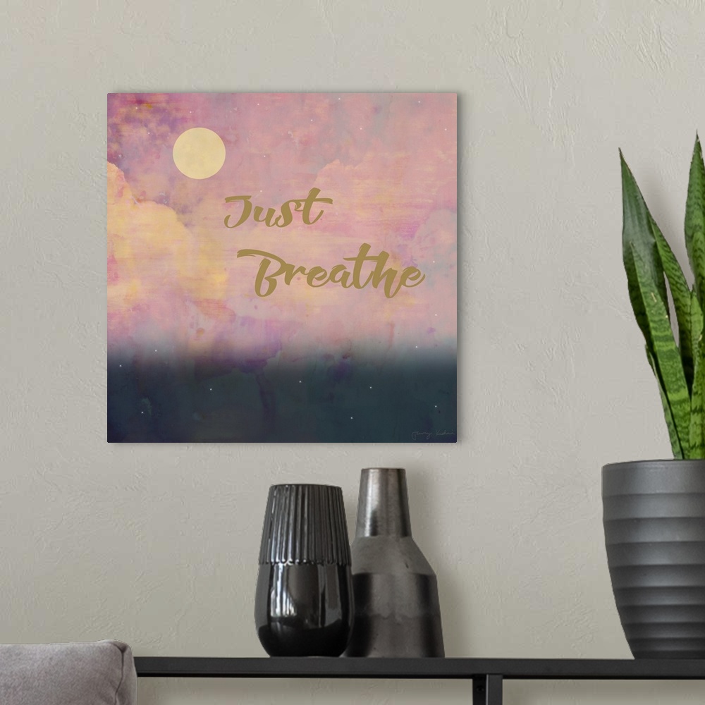 A modern room featuring "Just Breathe" in gold with a pink cloud design in the background.
