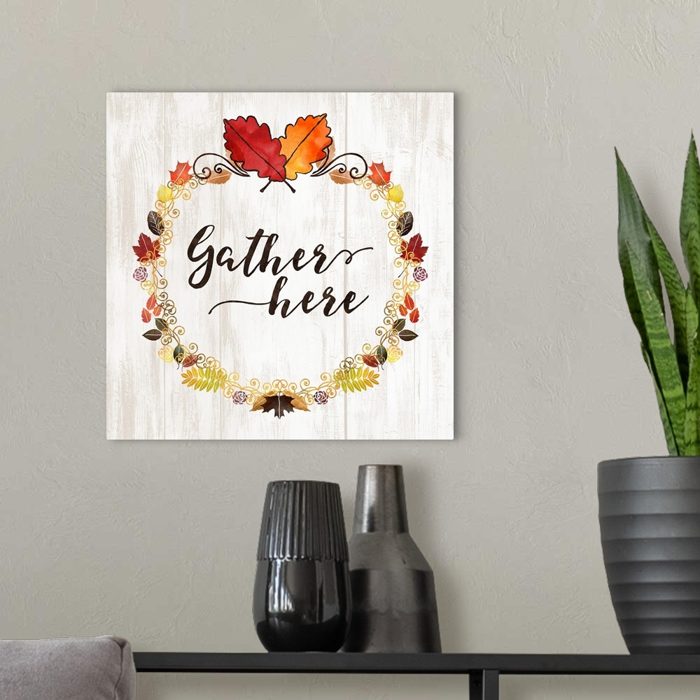 A modern room featuring "Gather Here" with a seasonal wreath and autumn leaves on a white wood backdrop.