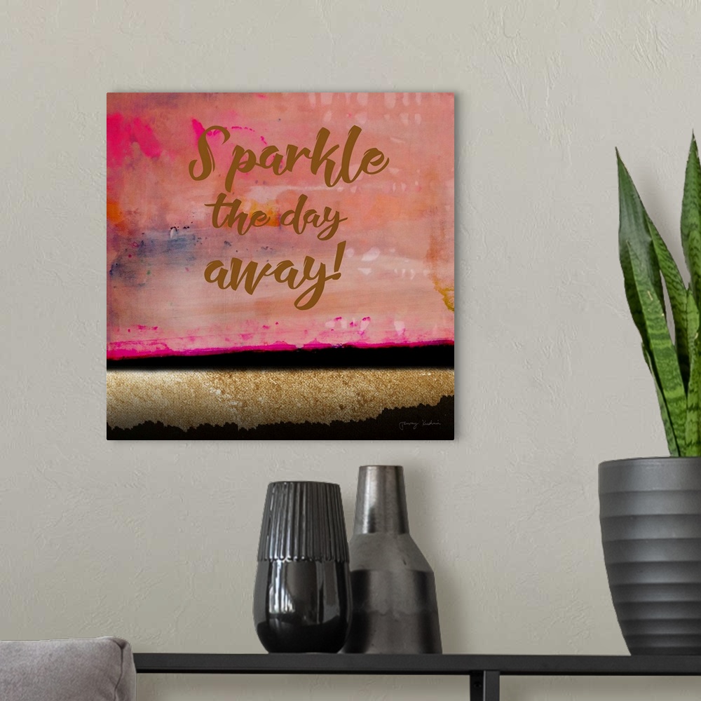 A modern room featuring "Sparkle The Day Away!" in brown against a brilliant colored abstract of colors of gold and pink.