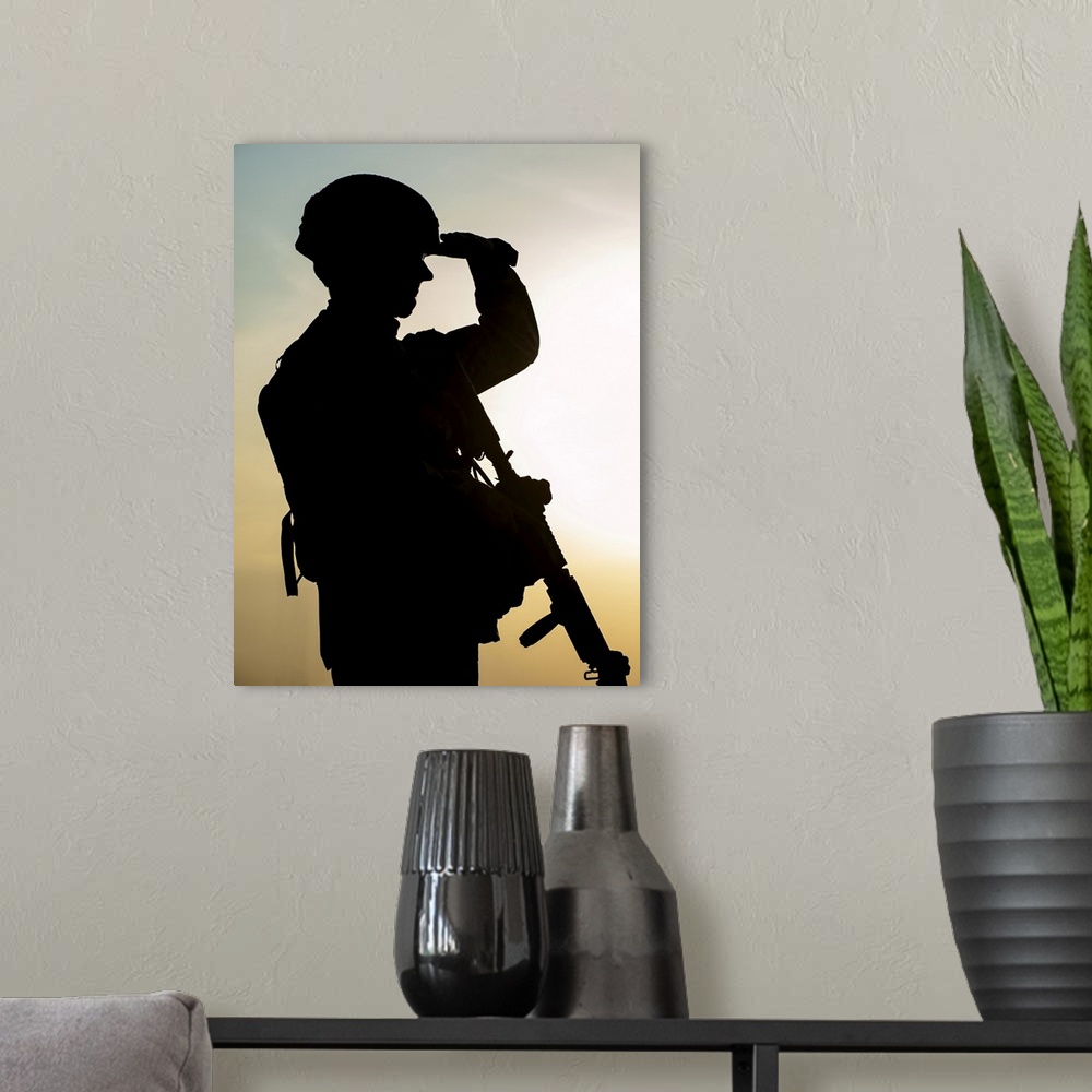 A modern room featuring Silhouette of U.S. soldier with rifle against the sunset.