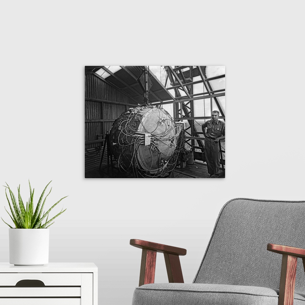 A modern room featuring World War II photograph of the Trinity Test bomb partially assembled on the test tower.