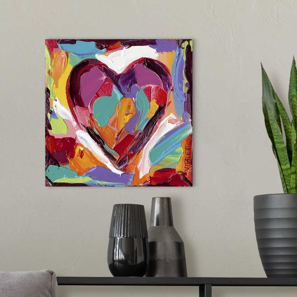 A modern room featuring Artwork of a technicolor heart with heavy dabs of paint and vivid colors.