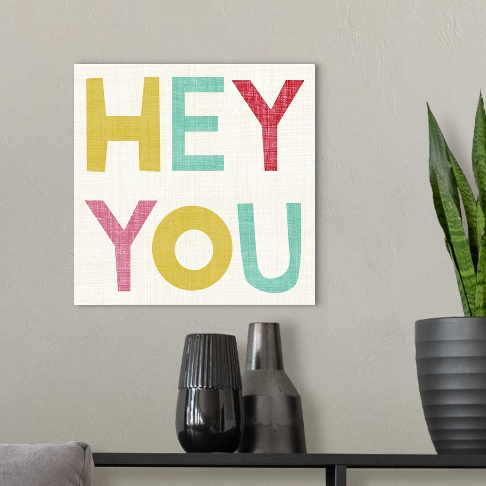 A modern room featuring Cute typography design with the words "Hey You" in large, pastel letters.