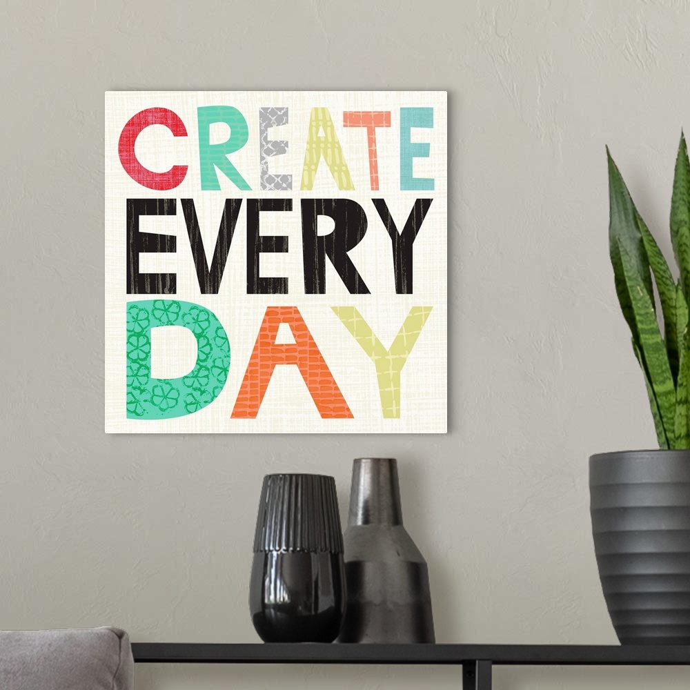 A modern room featuring Children's typography artwork in colorful block letters reading "Create Every Day."