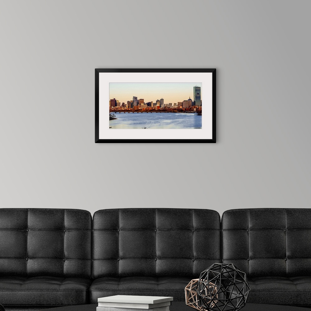 A modern room featuring Panoramic view of the Boston City skyline at sunset, seen from across the water.