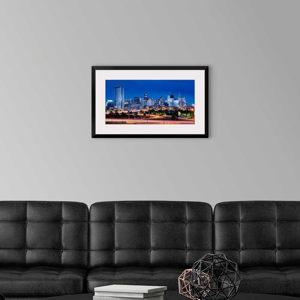 A modern room featuring Photo of Denver's skyline at night with light trails.