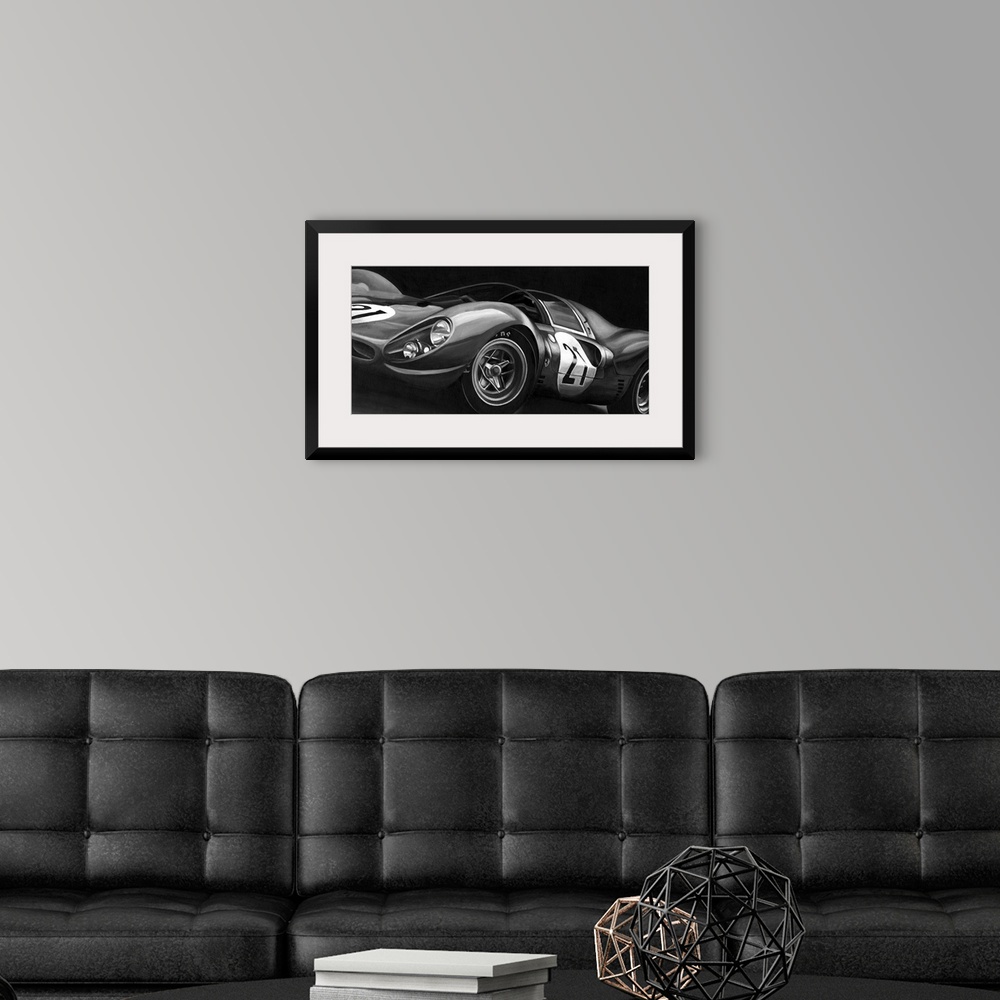 A modern room featuring Landscape, large vintage art in black and white of the side view of a rounded race car with the n...