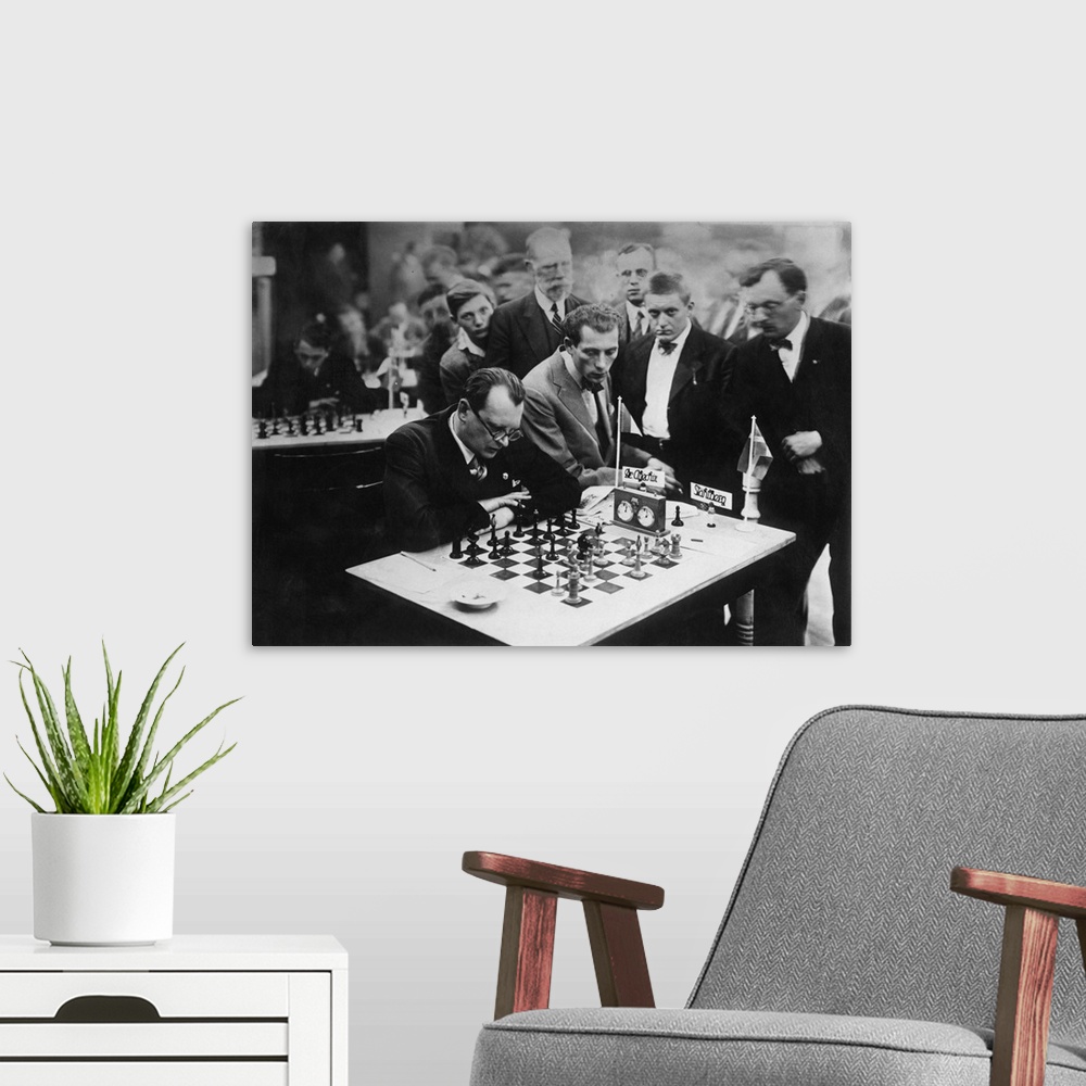 Alexander Alekhine siting while playing a chess. - Reprint