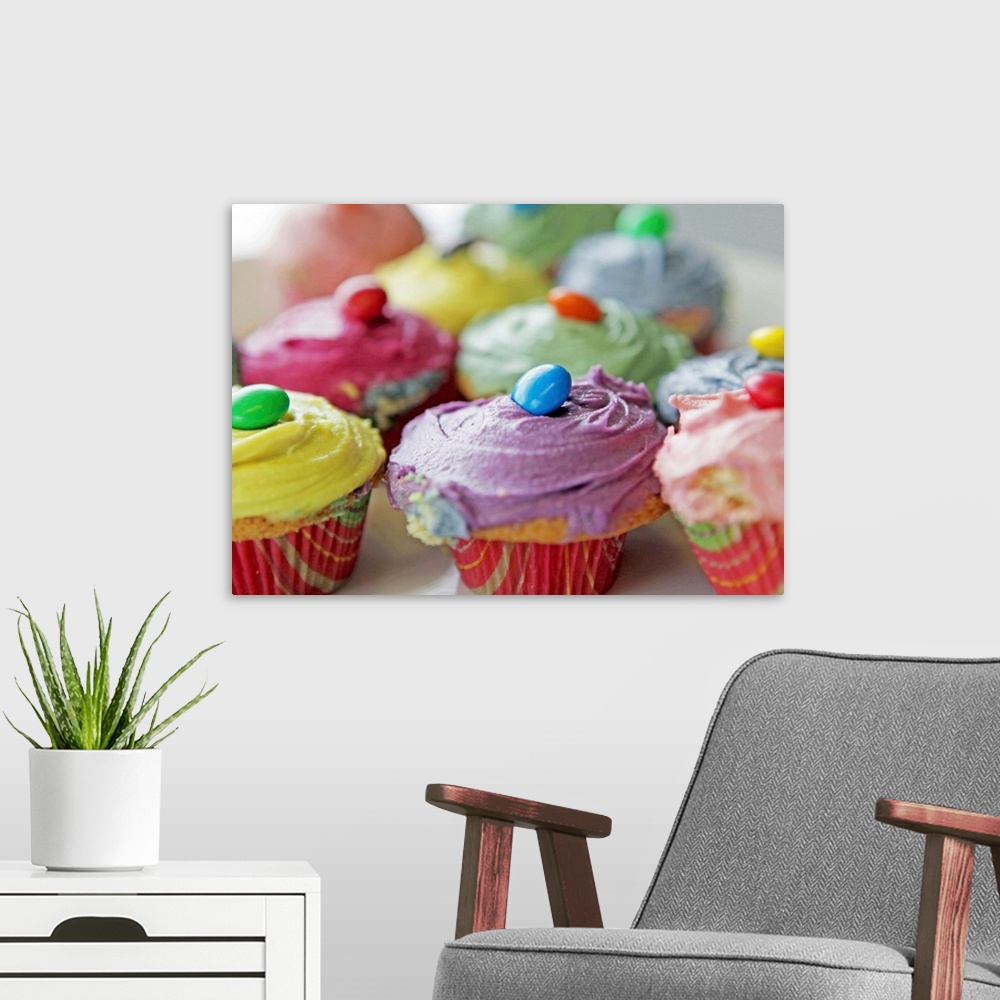 A modern room featuring Various colorful homemade cupcakes.