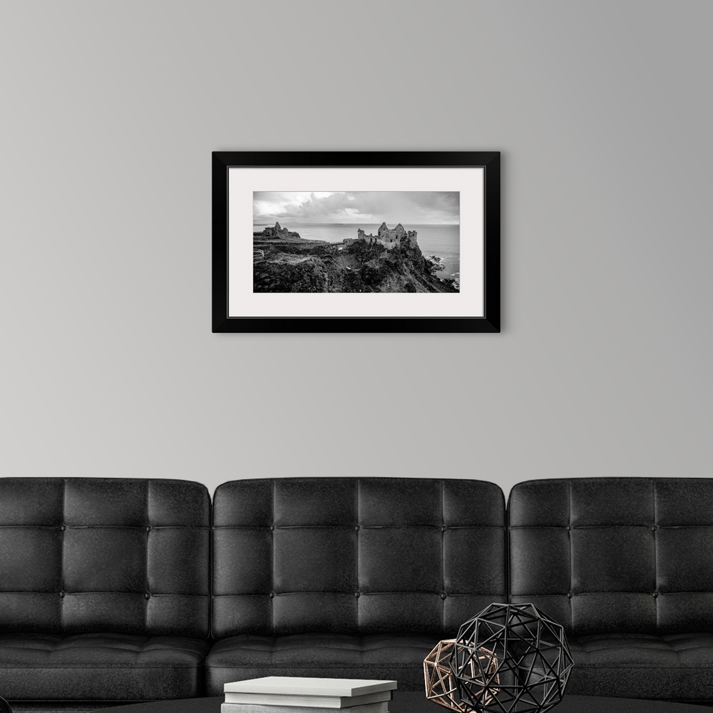 A modern room featuring Landscape photograph of Dunluce Castle next to the ocean, taken from a higher point.