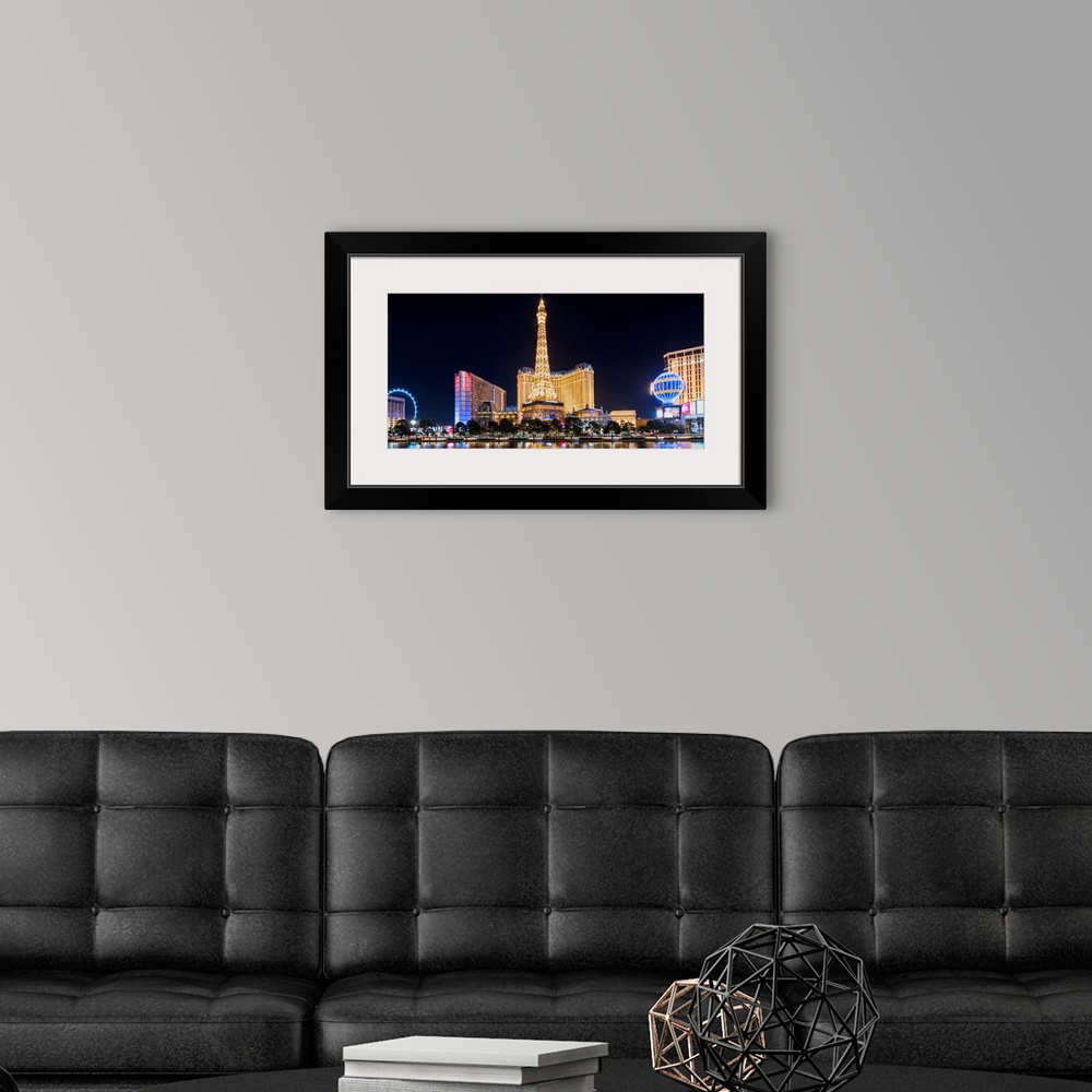 A modern room featuring Panoramic photograph of the Las Vegas Strip lit up at night highlighting the Eiffel Tower Restaur...