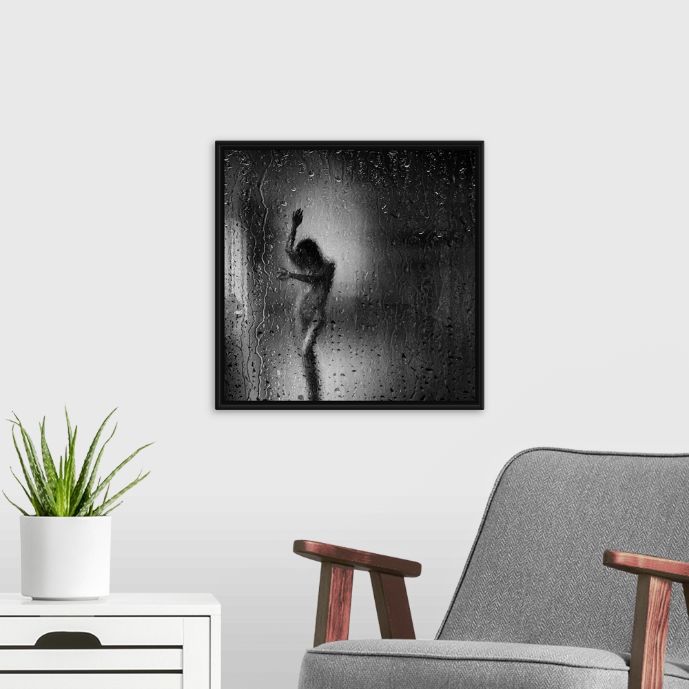 A modern room featuring Square black and white fine art photograph of a nude woman through a rainy window glass.