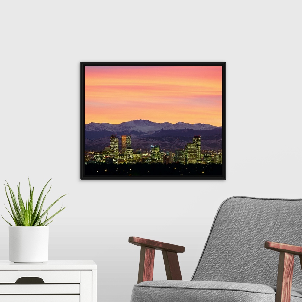 A modern room featuring Large photograph taken of the Denver, Colorado skyline at dusk.  The snow covered mountains in th...