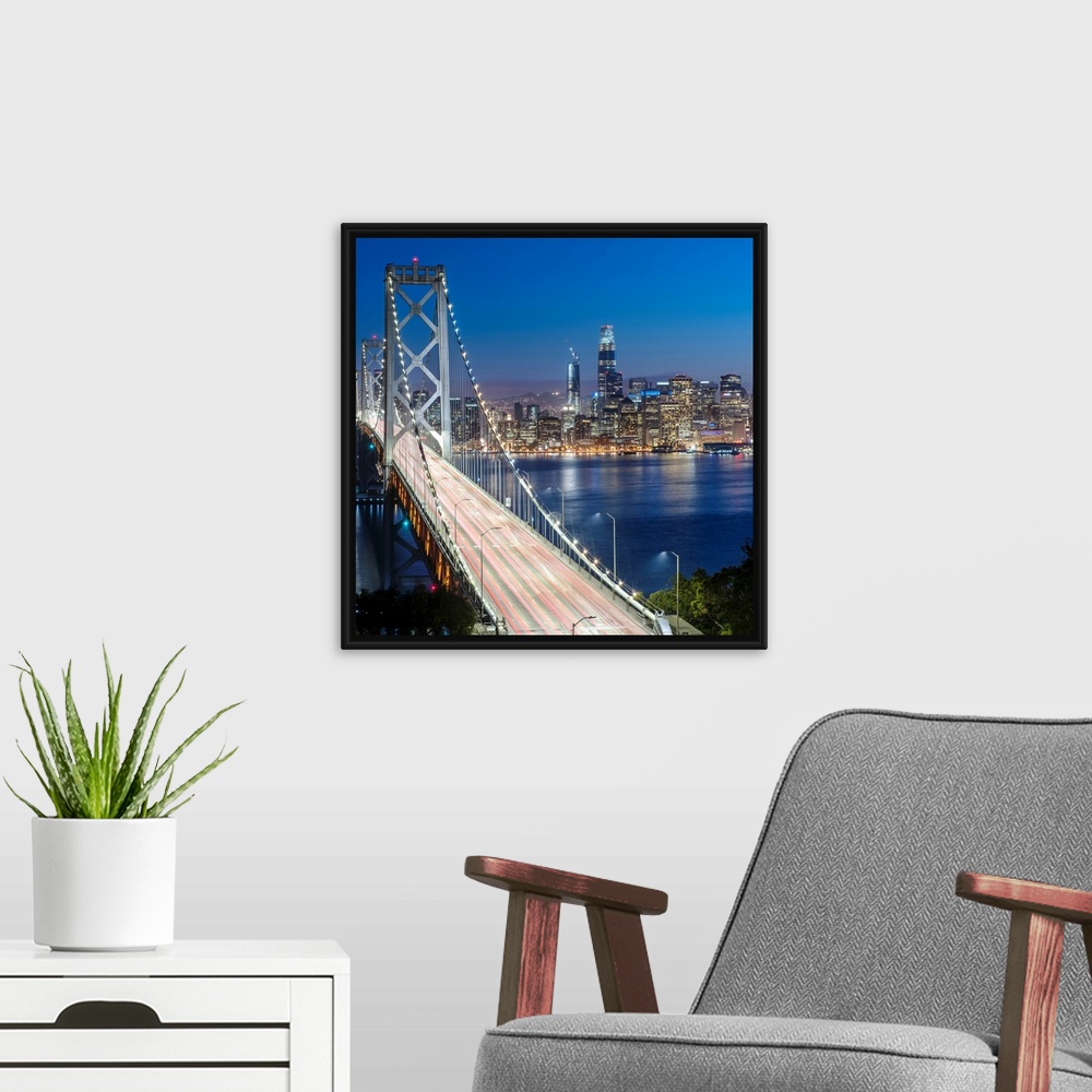 A modern room featuring Square photograph of the Bay Bridge at dusk with downtown San Francisco lit up in the background.