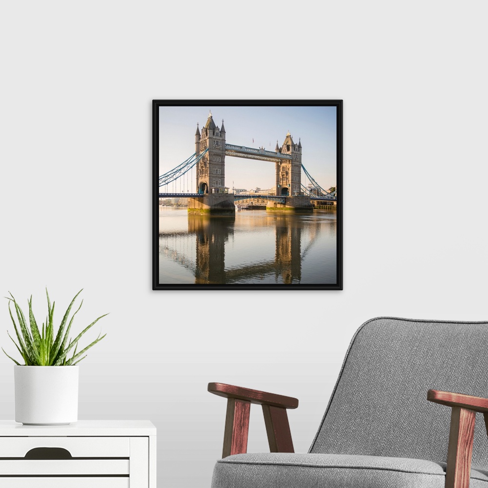A modern room featuring Square photograph of Tower Bridge reflecting into the River Thames in London, England, UK.