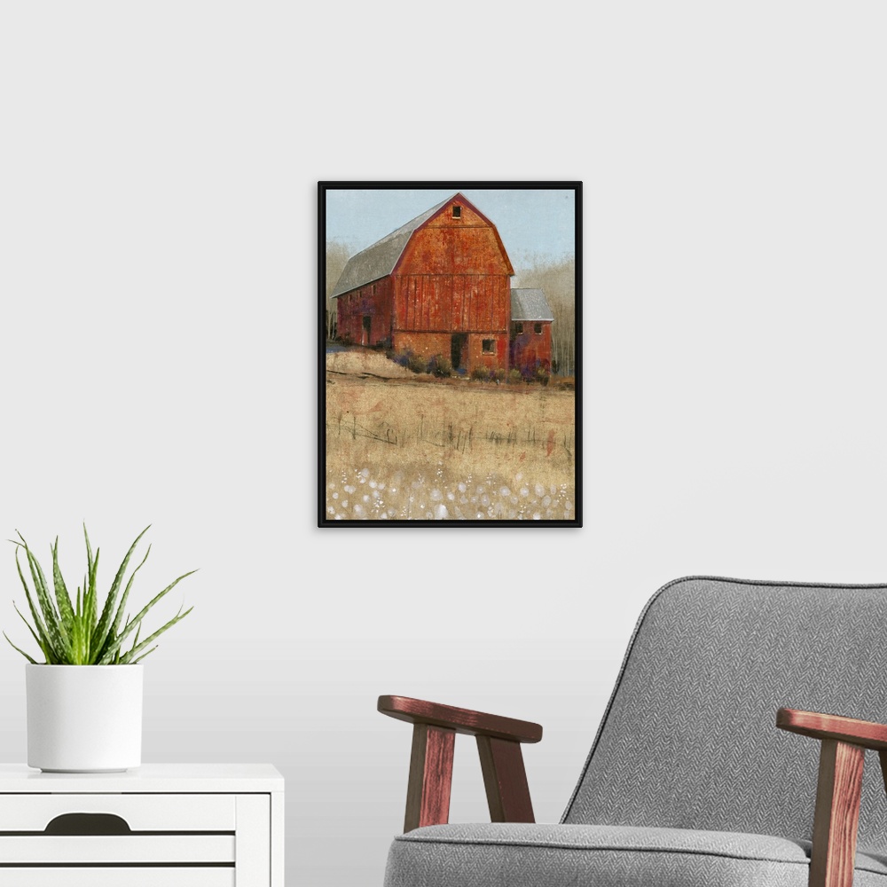 A modern room featuring Countryside artwork of rustic red barn on a straw colored field.