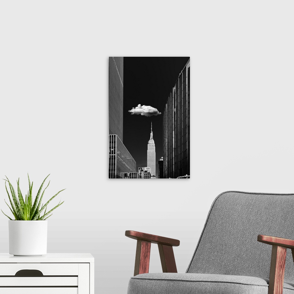A modern room featuring Black and white photograph of a New York City cityscape highlighting the single cloud hanging ove...