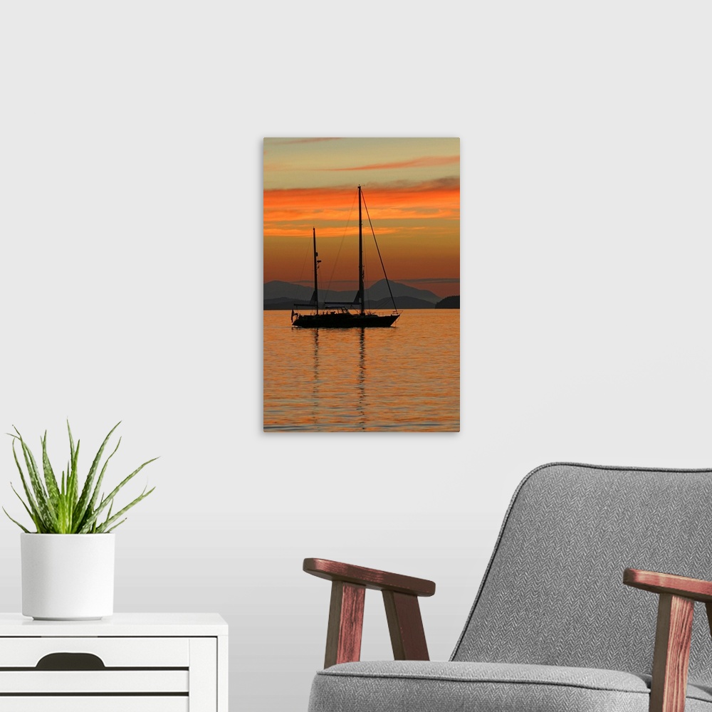 A modern room featuring Beautiful photograph of a sail boat sitting in the water with mountains in the background as the ...
