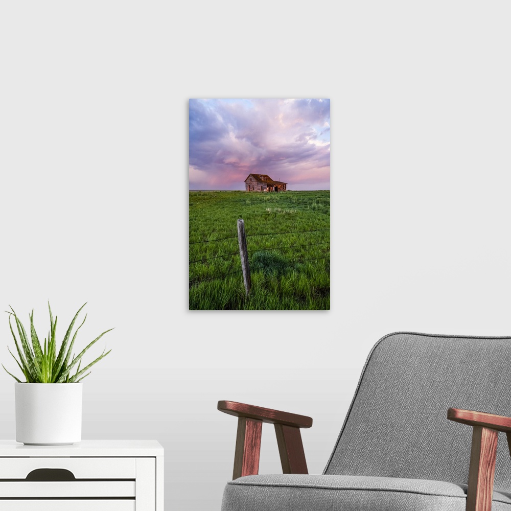 A modern room featuring Abandoned barn on farmland with storm clouds glowing pink; Val Marie, Saskatchewan, Canada