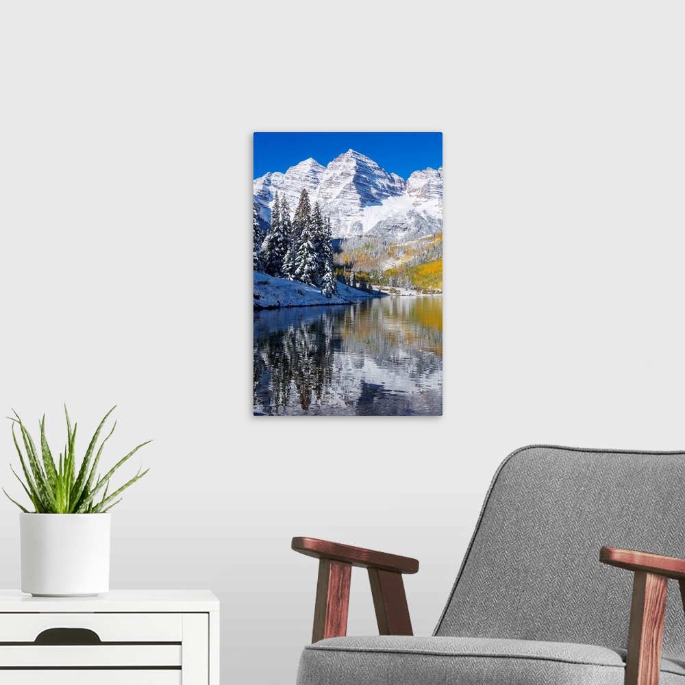 A modern room featuring Snow covered mountains are pictured against a clear blue background that reflects down in the bod...
