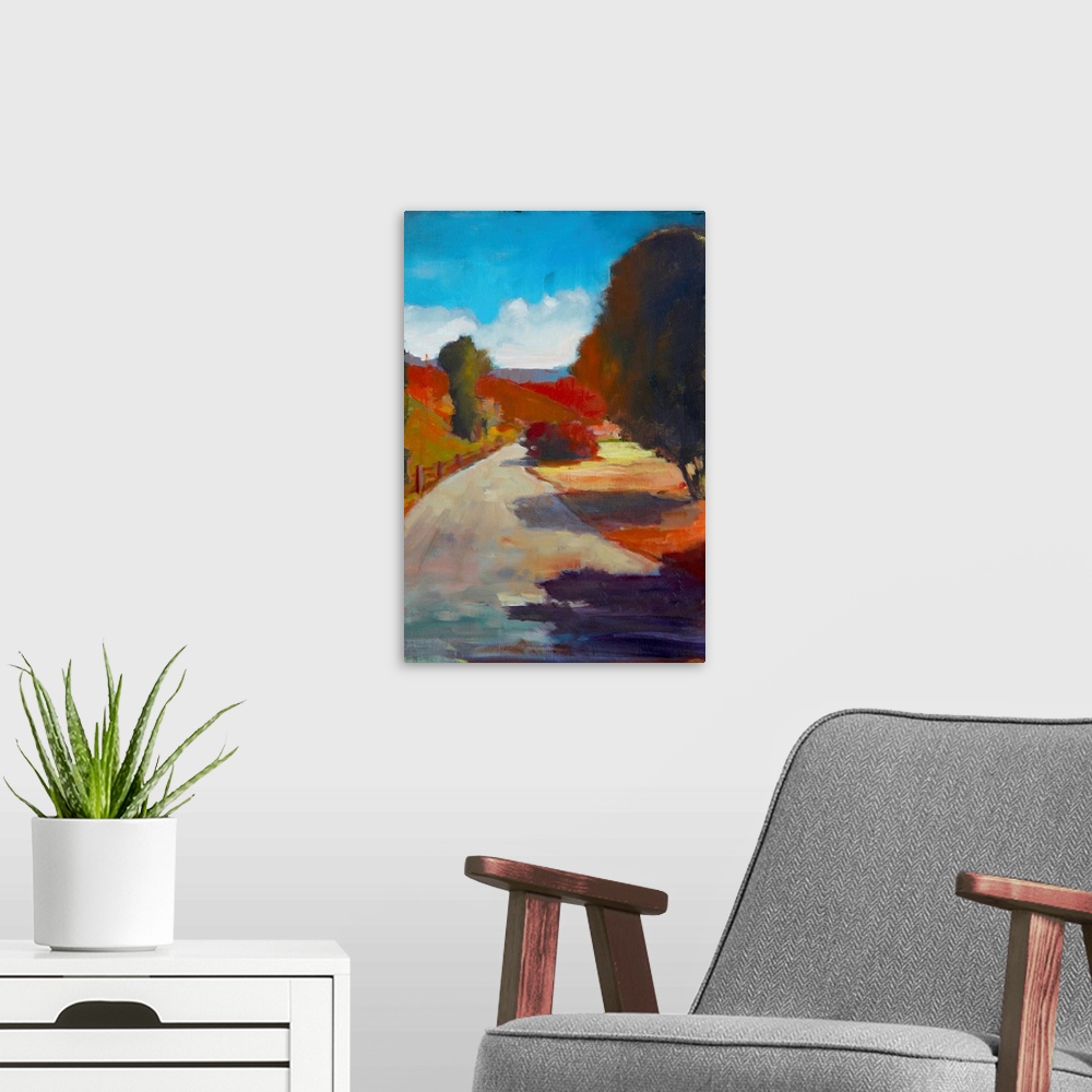 A modern room featuring Landscape painting of a country road surrounded by grass and trees in Autumn colors.