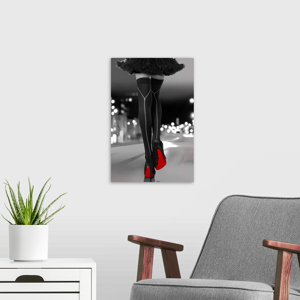 A modern room featuring Black and white photograph of a woman's long legs with black high heels and bright red soles walk...
