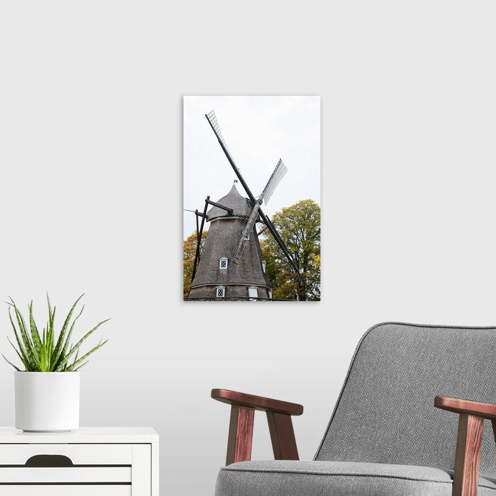 A modern room featuring Copenhagen, Denmark - A historic old style windmill after having been restored. Vertical shot.