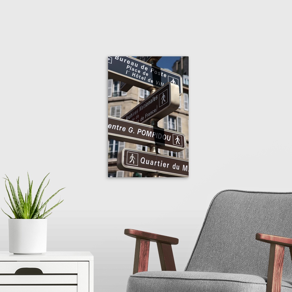 A modern room featuring France. Paris. Direction signs on the street