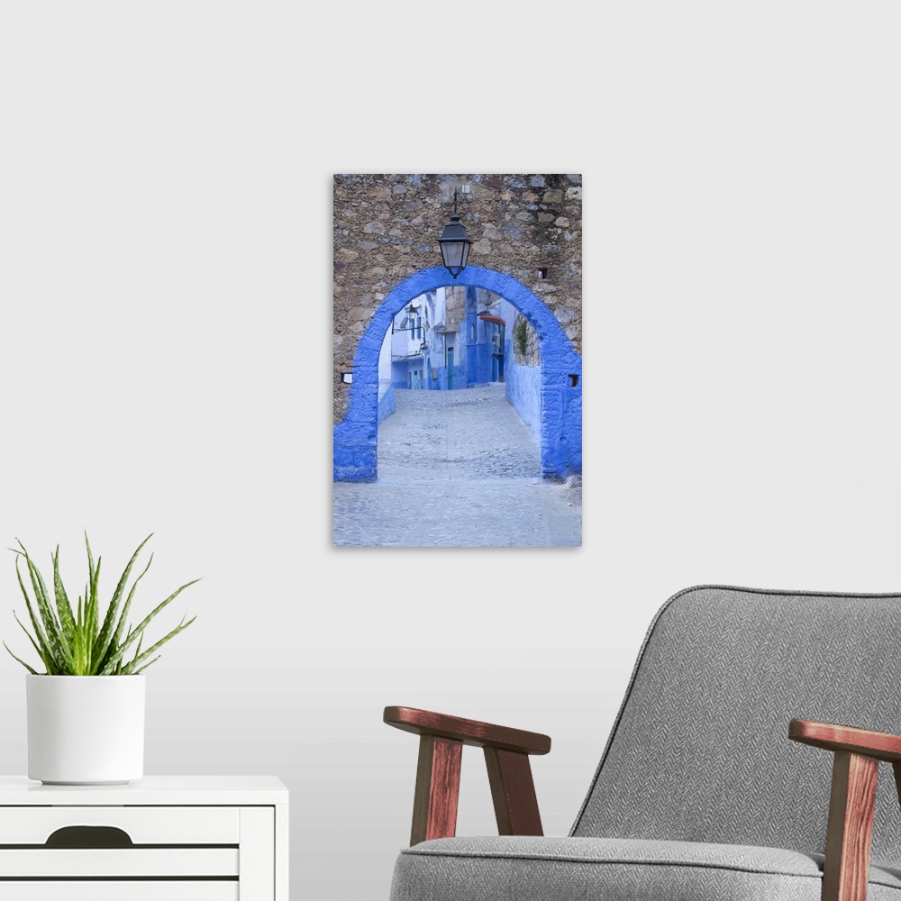 A modern room featuring Morocco, Chefchaouen. A blue arch and quiet street entering the medina of the village.