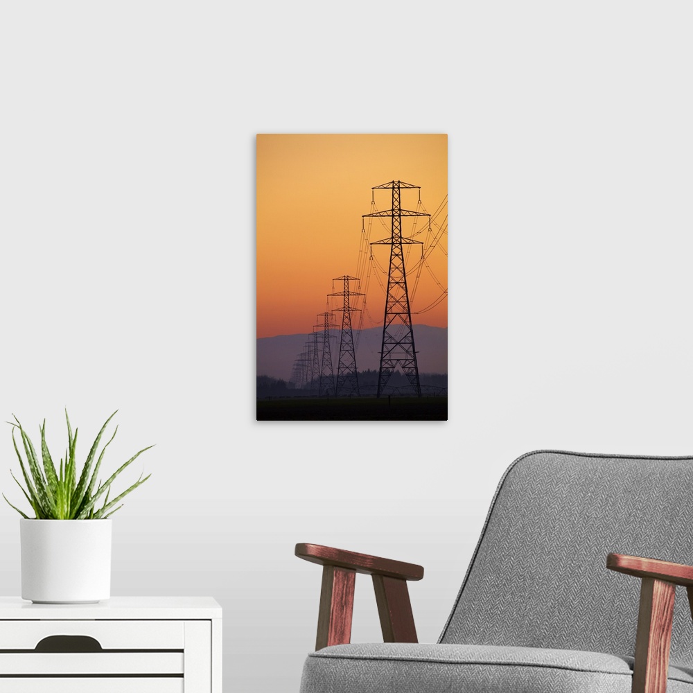 A modern room featuring Row of power pylons at sunset, Mid Canterbury, South Island, New Zealand.