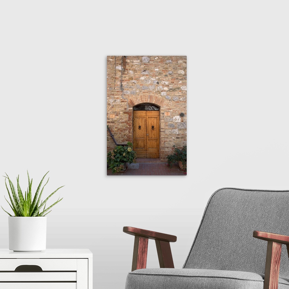 A modern room featuring Sienna, Tuscany, Italy - Wooden doors in a brick and stone building. Vertical shot.
