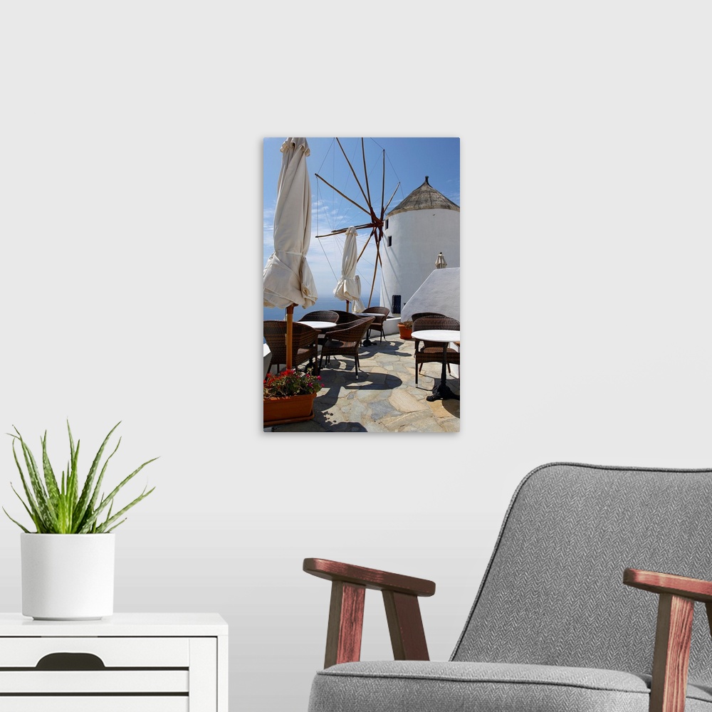 A modern room featuring Restaurant on deck with windmill overlooking ocean in Santorini, Greece