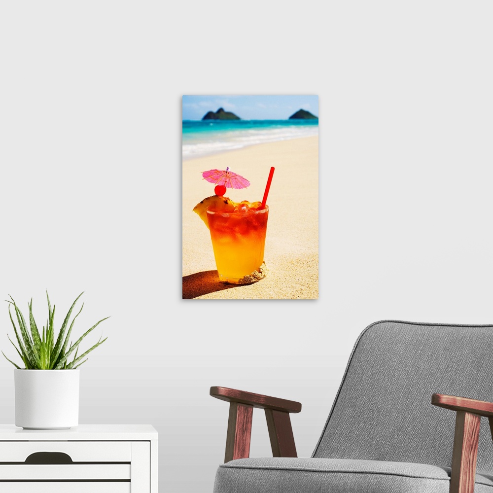 A modern room featuring A mai tai garnished with pinapple and a cherry, sitting in the sand on the beach.