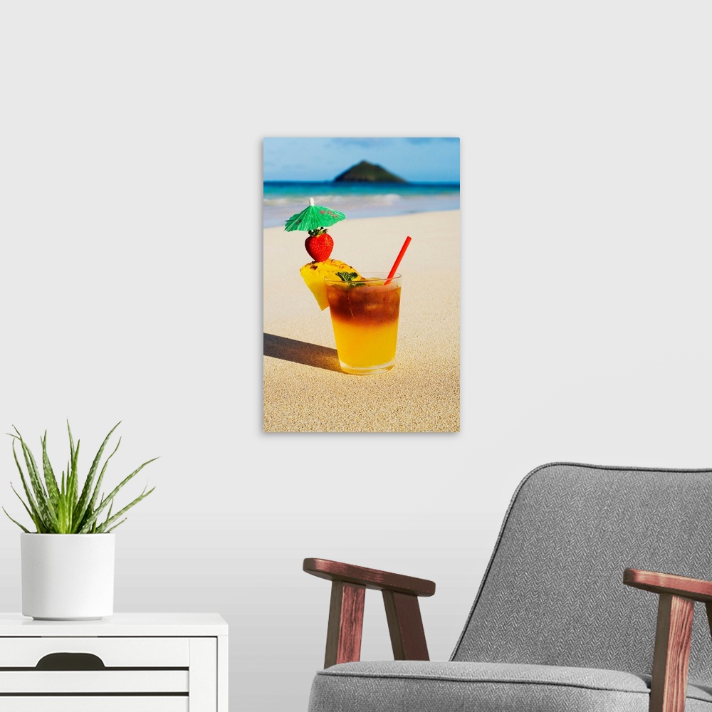 A modern room featuring A mai tai garnished with pinapple and a strawberry, sitting in the sand on the beach.
