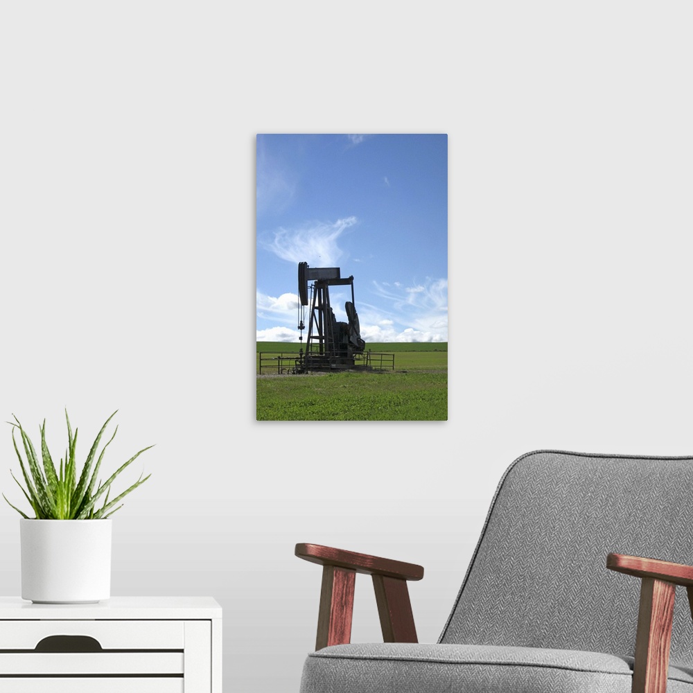 A modern room featuring An oil pumpjack stands alone in a prairie field in Southern Alberta.