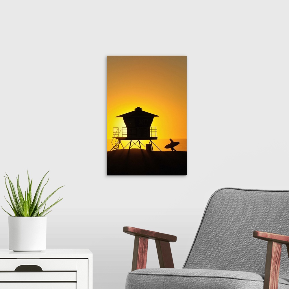 A modern room featuring Surfer and Lifeguard tower silhouetted against setting sun.