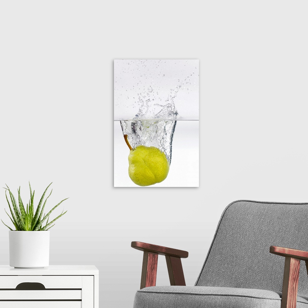 A modern room featuring Action photography shot of a ripe pear splashing in to crystal clear water.