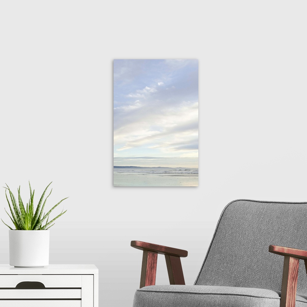 A modern room featuring Sunrise on Woodend beach, Christchurch, South Island New Zealand, portrait composition, cloudy da...