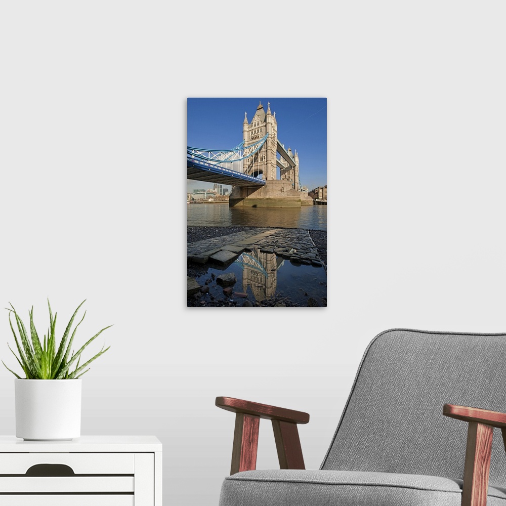 A modern room featuring Tower Bridge, the River Thames and the Tower of London reflected in a pool, London.