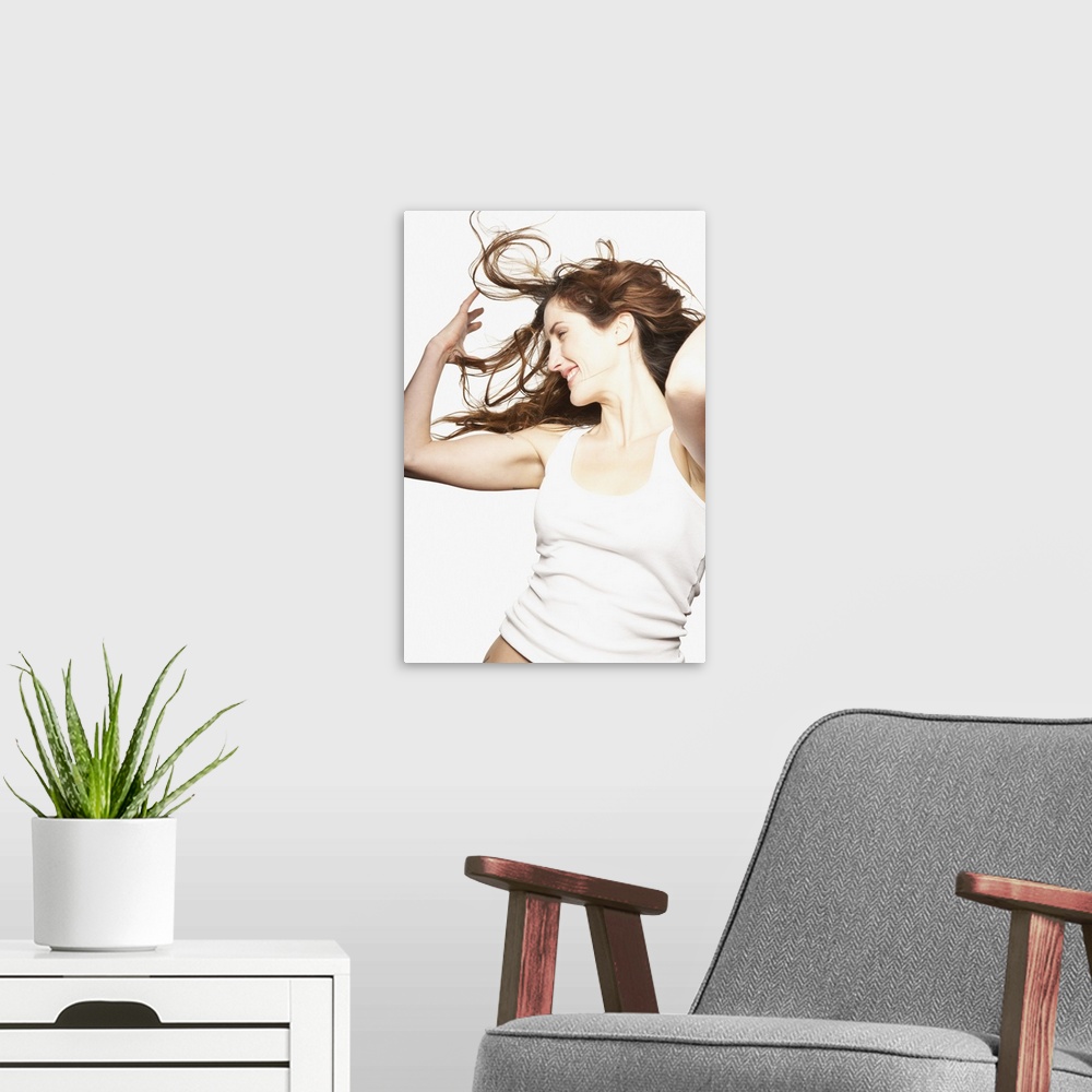 A modern room featuring Young woman in white tank top tossing hair