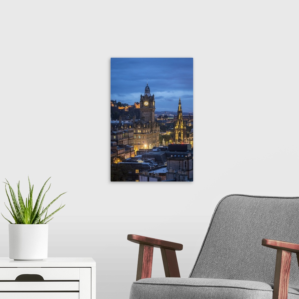 A modern room featuring Illuminated Balmoral Hotel clock tower and Scott Monument seen from Observatory House at dusk, UN...