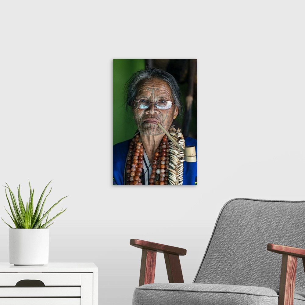 A modern room featuring Close-up portrait of old lady with glasses and traditional facial tattoo smoking a pipe, Mindat, ...